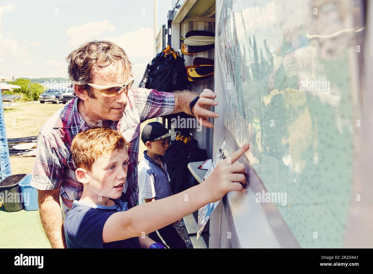 Vater und Sohn schauen sich die Karte an, bevor sie sich auf eine Kajaktour in Casco Bay begeben Stockfoto