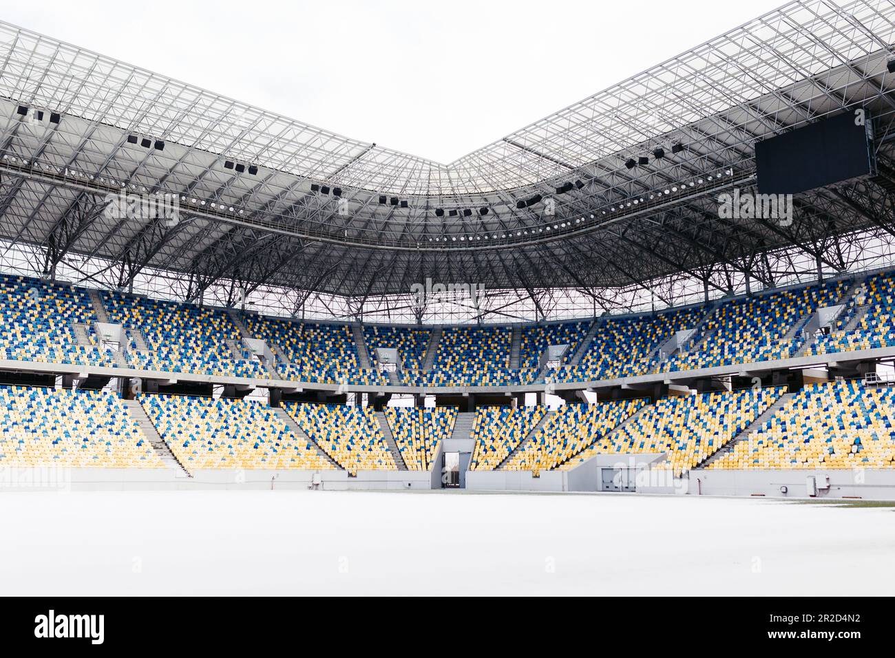 Ein modernes Stadion mit leeren Ständen und einem schneebedeckten Feld Stockfoto