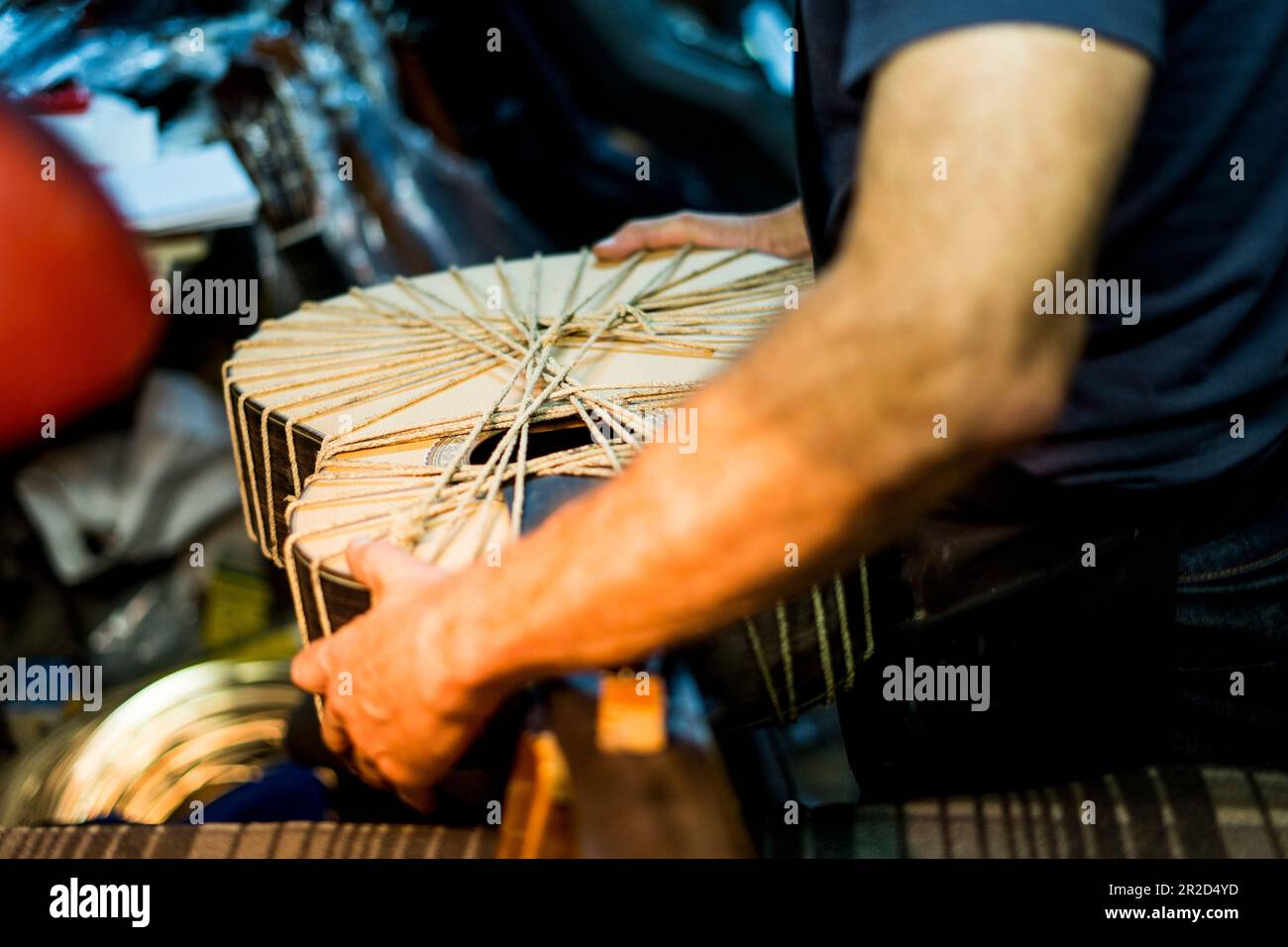 Luthier-Mann, der Gitarren in einer Kunsthandwerkstatt in Spanien macht. Stockfoto