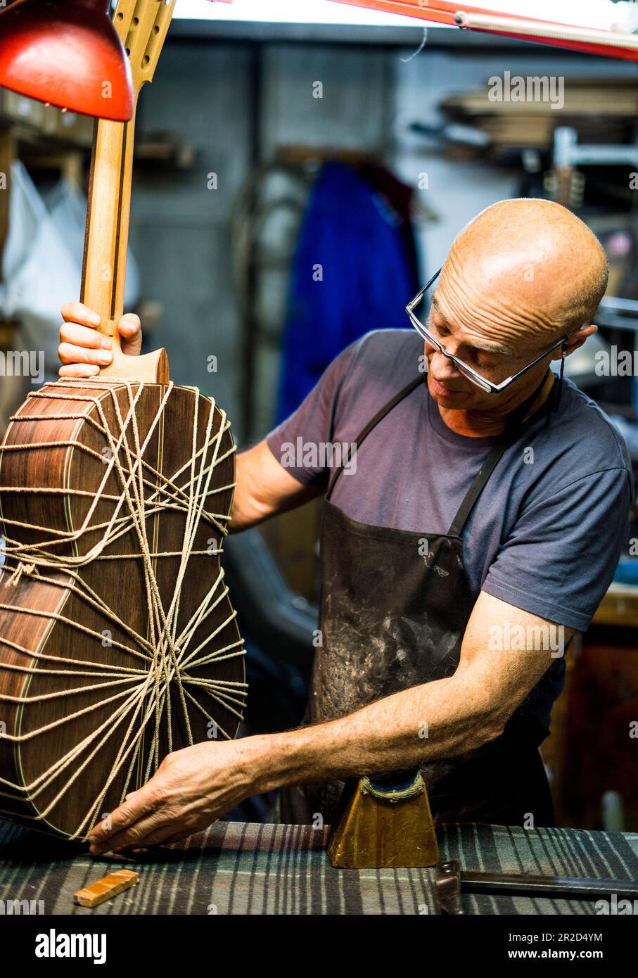 Luthier-Mann, der Gitarren in einer Kunsthandwerkstatt in Spanien macht. Stockfoto