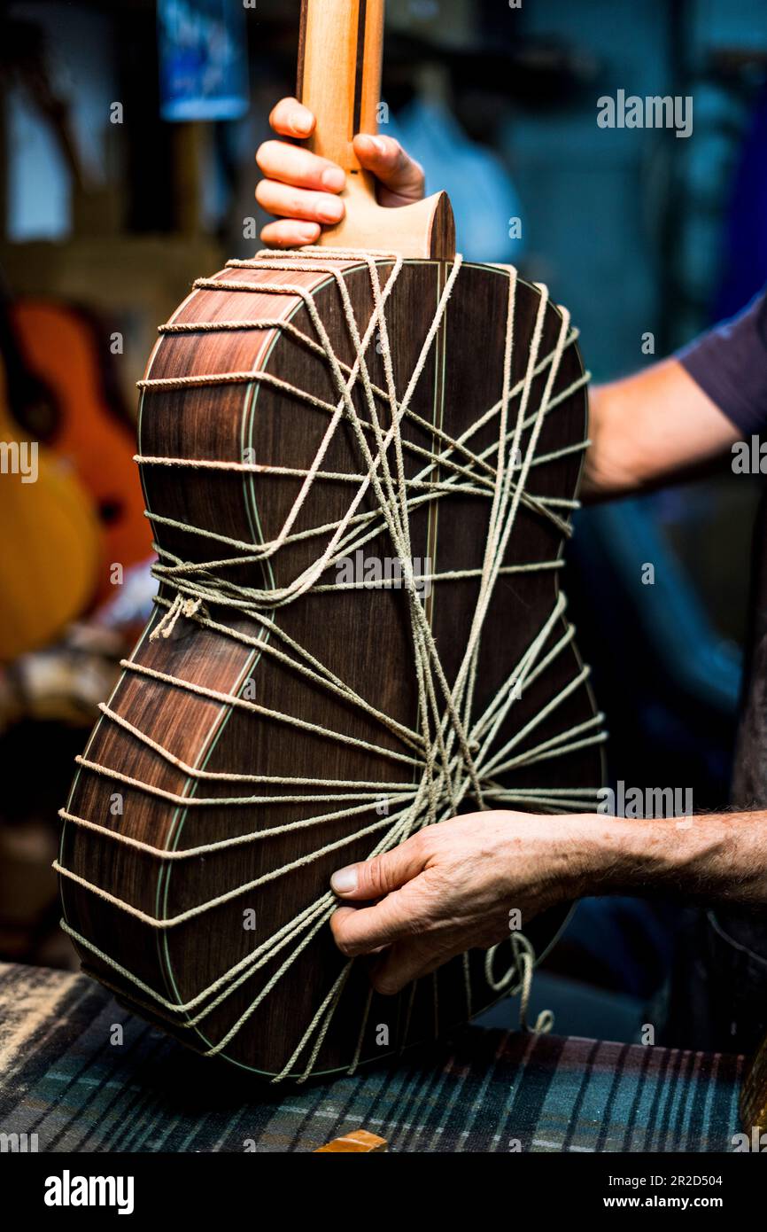 Luthier-Mann, der Gitarren in einer Kunsthandwerkstatt in Spanien macht. Stockfoto