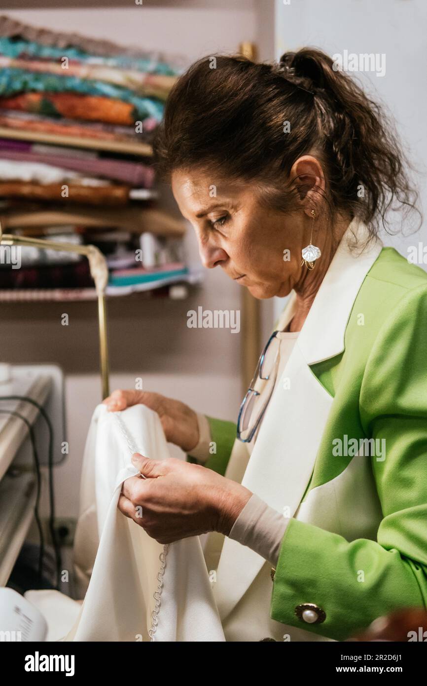 Schneiderin, die das Kleid in ihrer Nähwerkstatt vermisst Stockfoto