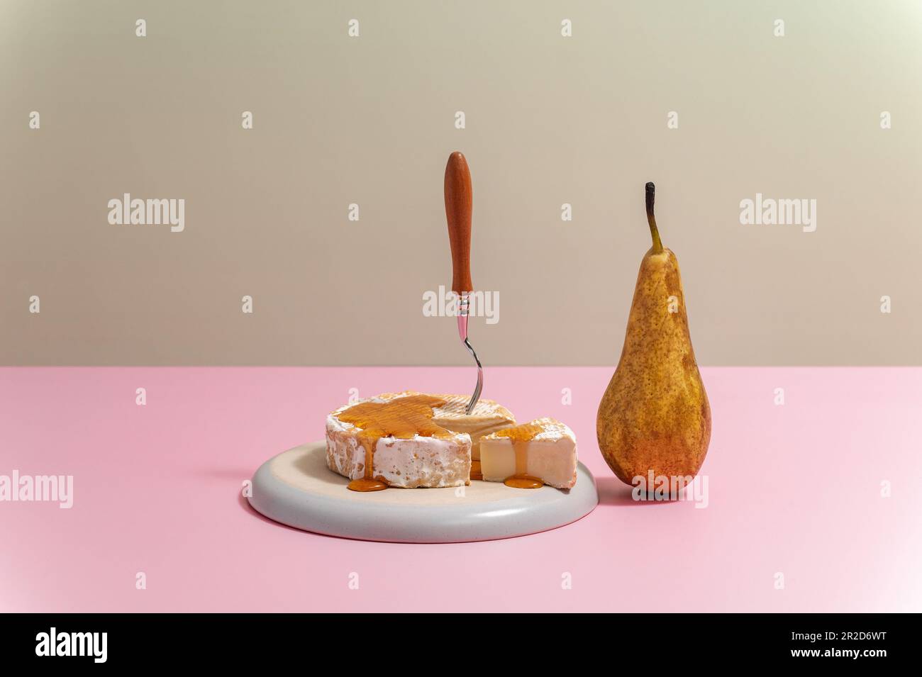 brie-Käse auf einem Teller mit Honig und Birne Stockfoto