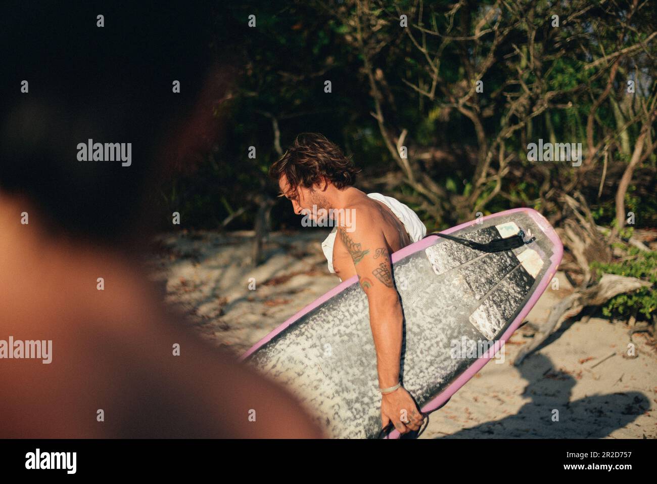 Ein Typ mit seinem Surfbrett am Strand Stockfoto