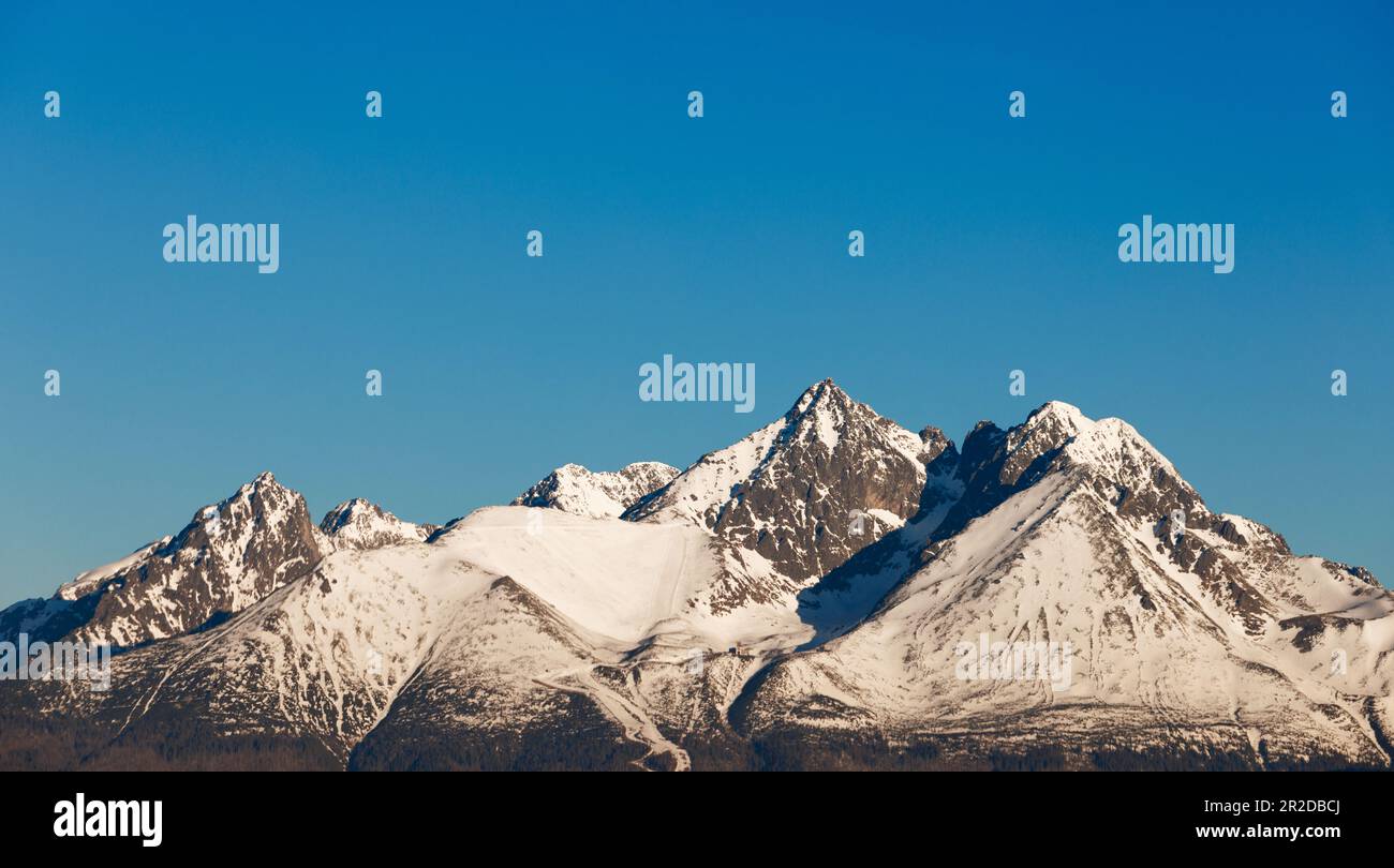 Schneebedeckte Berggipfel unter blauem Himmel Stockfoto