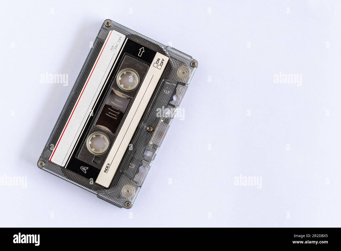 Altes klassisches Band aus dem 90s, das für die Aufnahme von Musik oder Geräuschen verwendet wird, auf einem weißen Tisch platziert, Nahaufnahme, selektiv fokussiert, weißes Bac Stockfoto