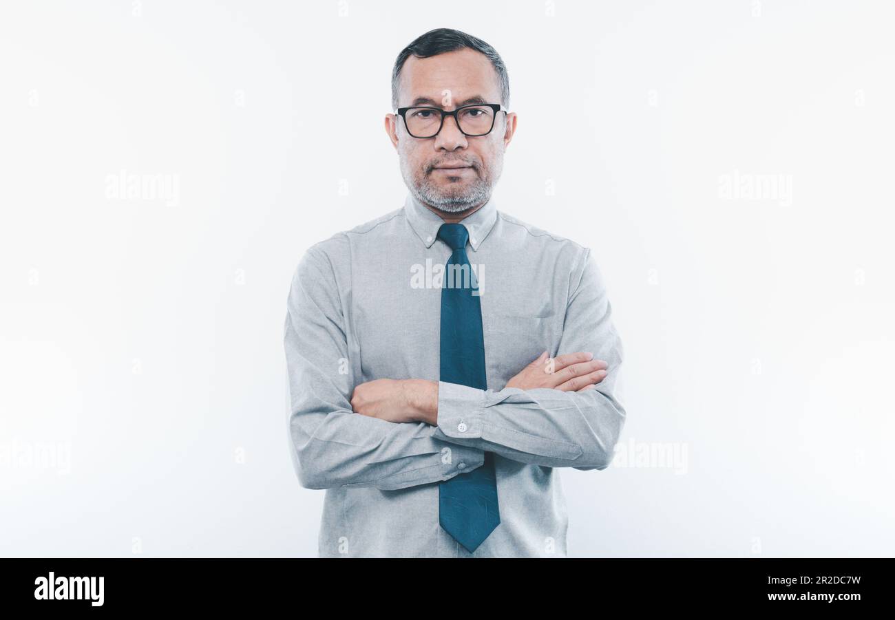 40-50 Jahre alter asiatischer Geschäftsmann schaut in die Kamera, faltete seine Arme und lächelte glücklich, nachdem er erfolgreich in Finanzen, Banken und Immobilien investiert hatte. Stockfoto