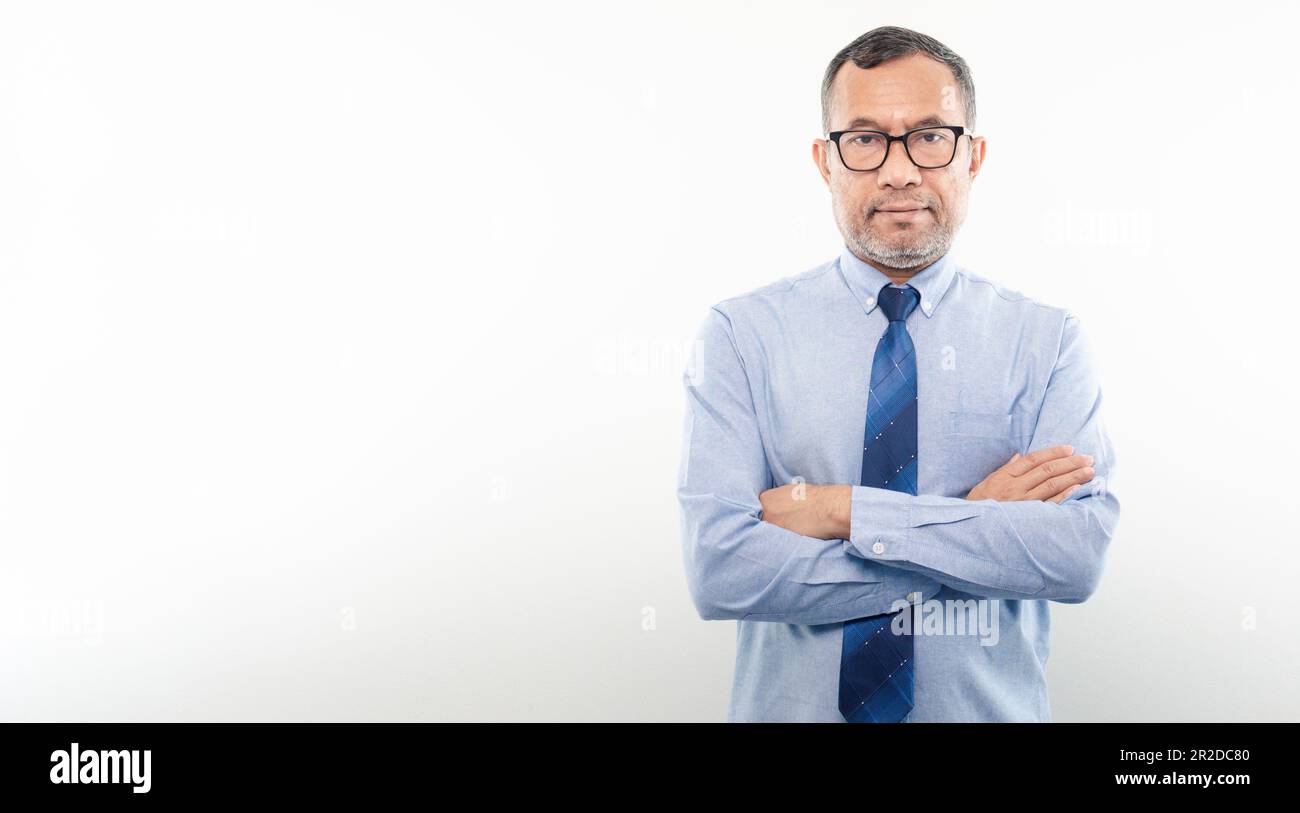 40-50 Jahre alter asiatischer Geschäftsmann schaut in die Kamera, faltete seine Arme und lächelte glücklich, nachdem er erfolgreich in Finanzen, Banken und Immobilien investiert hatte. Stockfoto