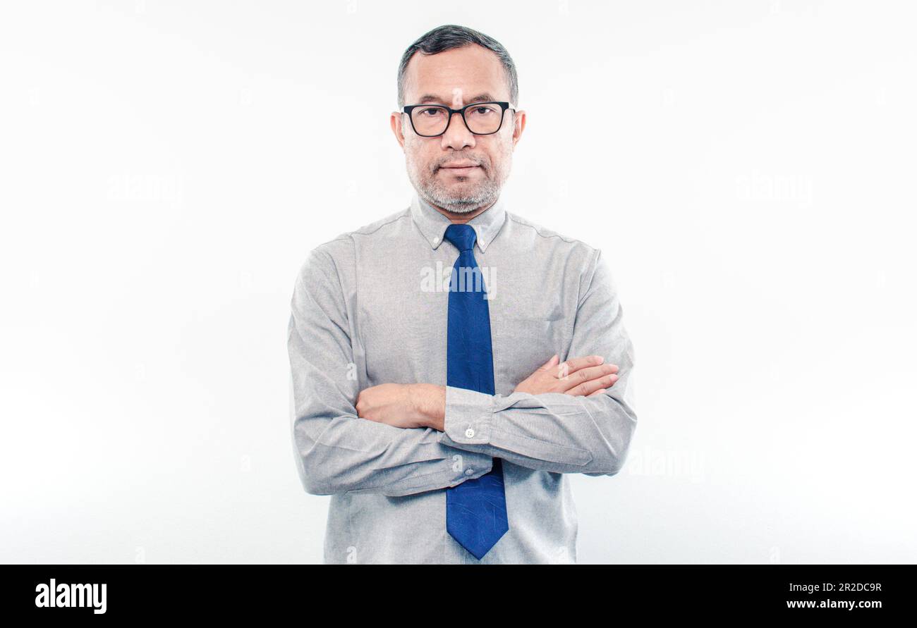 40-50 Jahre alter asiatischer Geschäftsmann schaut in die Kamera, faltete seine Arme und lächelte glücklich, nachdem er erfolgreich in Finanzen, Banken und Immobilien investiert hatte. Stockfoto