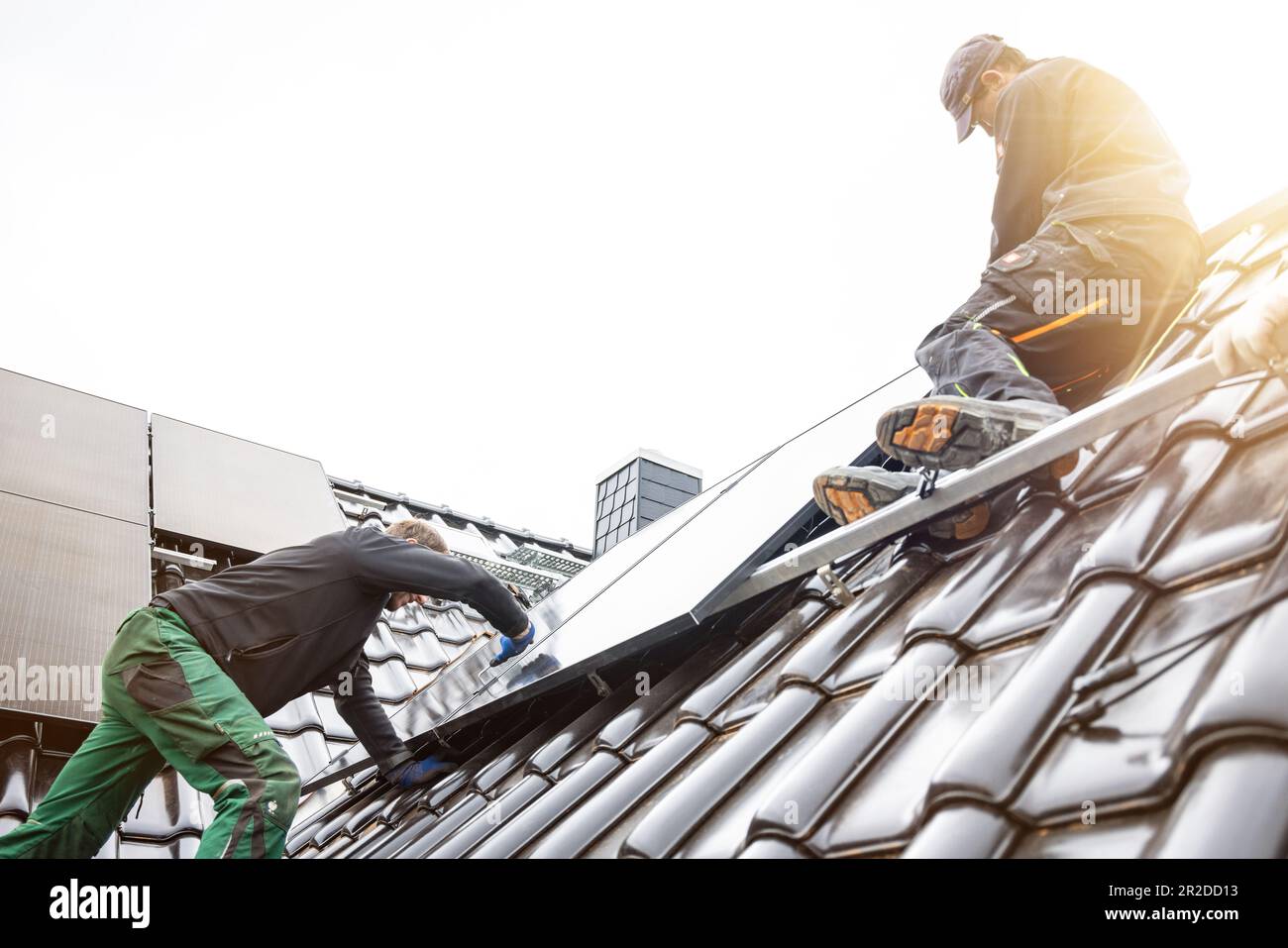 Techniker, die Solarpaneele auf dem Dach eines Hauses installieren Stockfoto