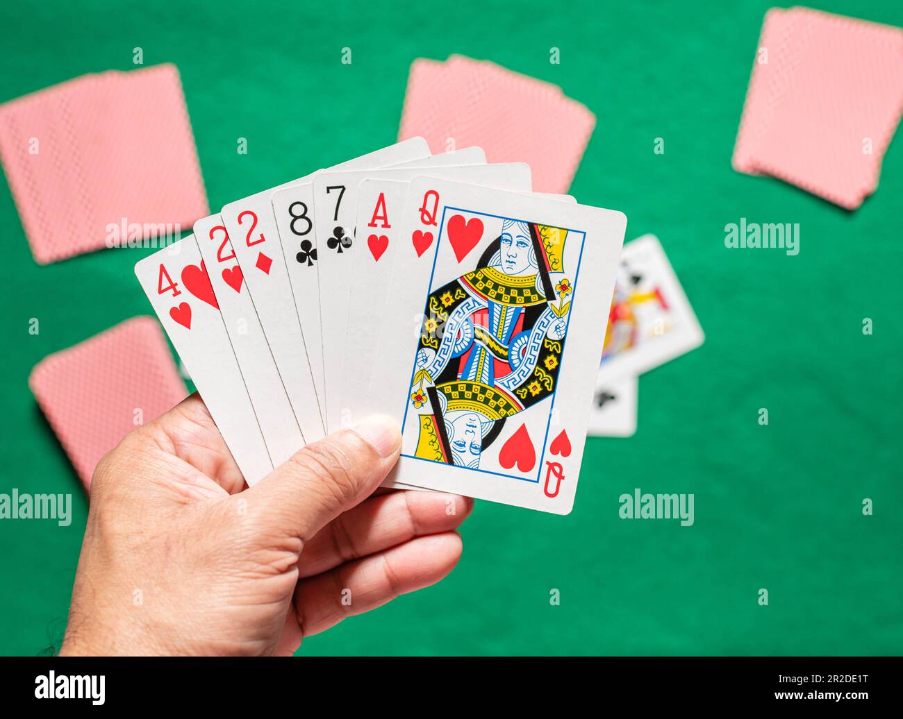 Songkhla, Hatyai, Thailand 12. März 2022: Nahaufnahme, Handkarten von Männern in Rommys Spiel auch als Kartenspiel bezeichnet. Unscharfer Hintergrund Stockfoto