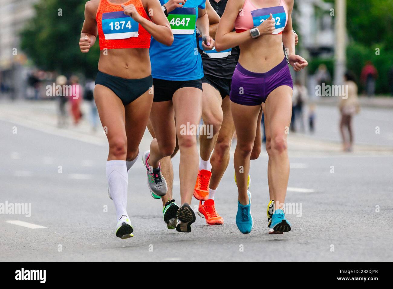 Vorderansicht in kleiner Gruppe, weibliche Läuferinnen, Athleten, die in der Stadt Marathon laufen, Sommersport-Rennen Stockfoto