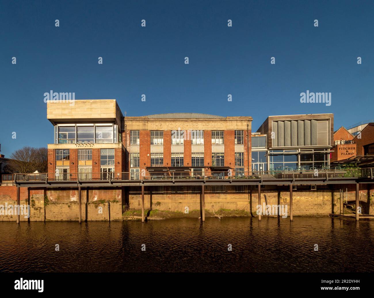 Die gemischte Architektur von Bars und Restaurants entlang des Nordufers der Ouse in York ist vor einem klaren blauen Himmel zu sehen. Stockfoto