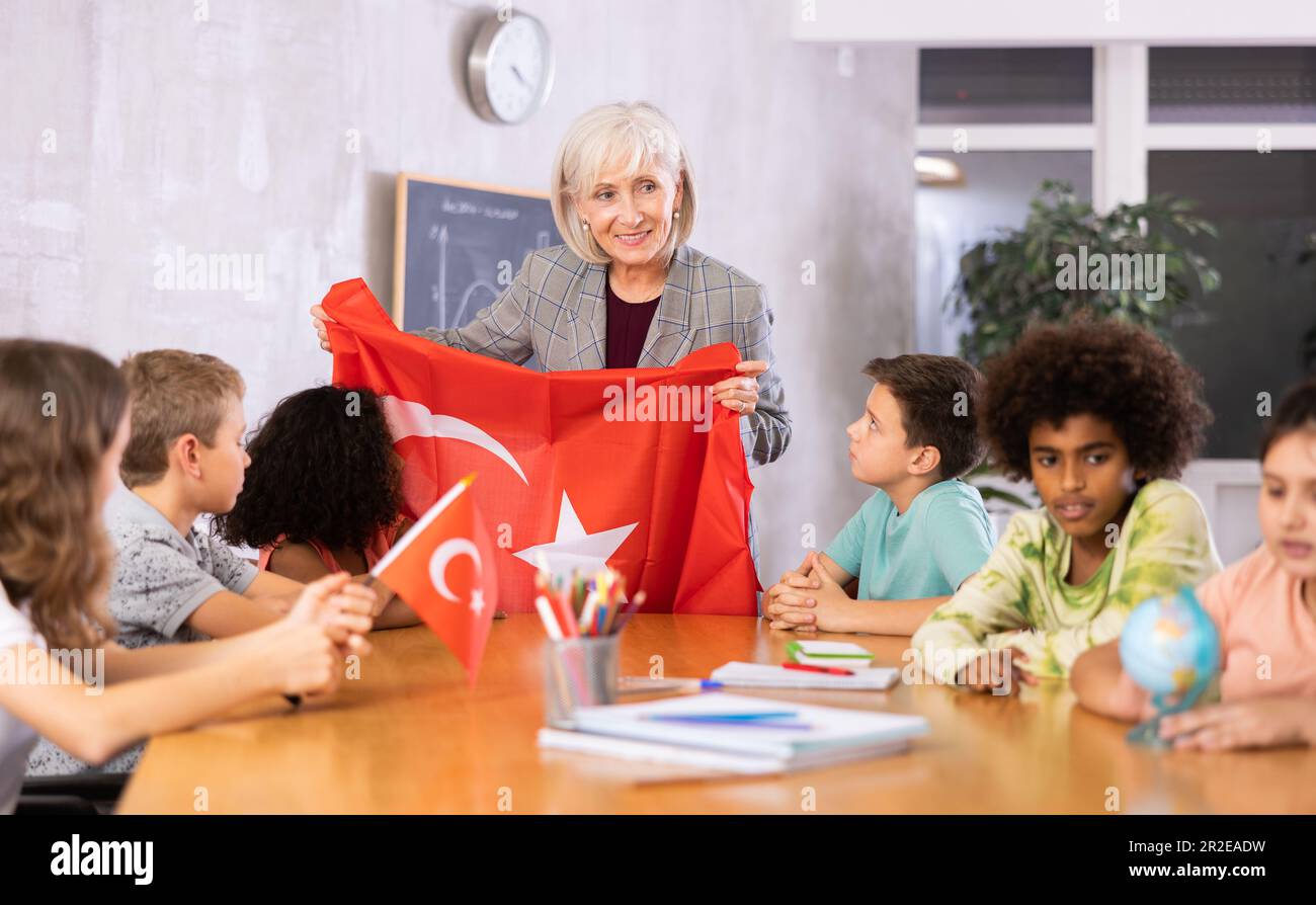 Eine lächelnde, reife Lehrerin erzählt den Schülern die Geschichte der Türkei Stockfoto
