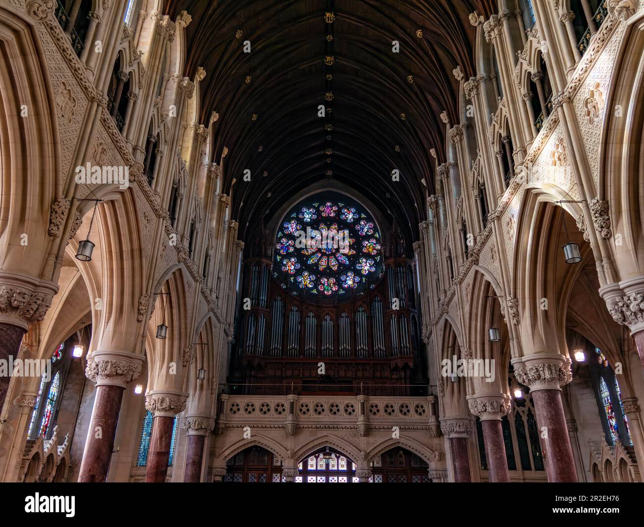 Ein großes mehrfarbiges Buntglasfenster in der römisch-katholischen Kirche der Stadt Cobh. Das Innere der Kathedrale St. Colman. Stockfoto