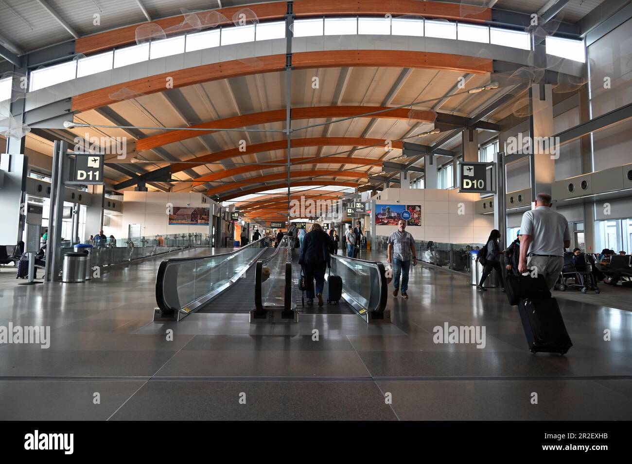 Reisende gehen durch den langen Flur zwischen den Toren im Terminal 2 des Raleigh-Durham International Airport in Raleigh, North Carolina. Stockfoto
