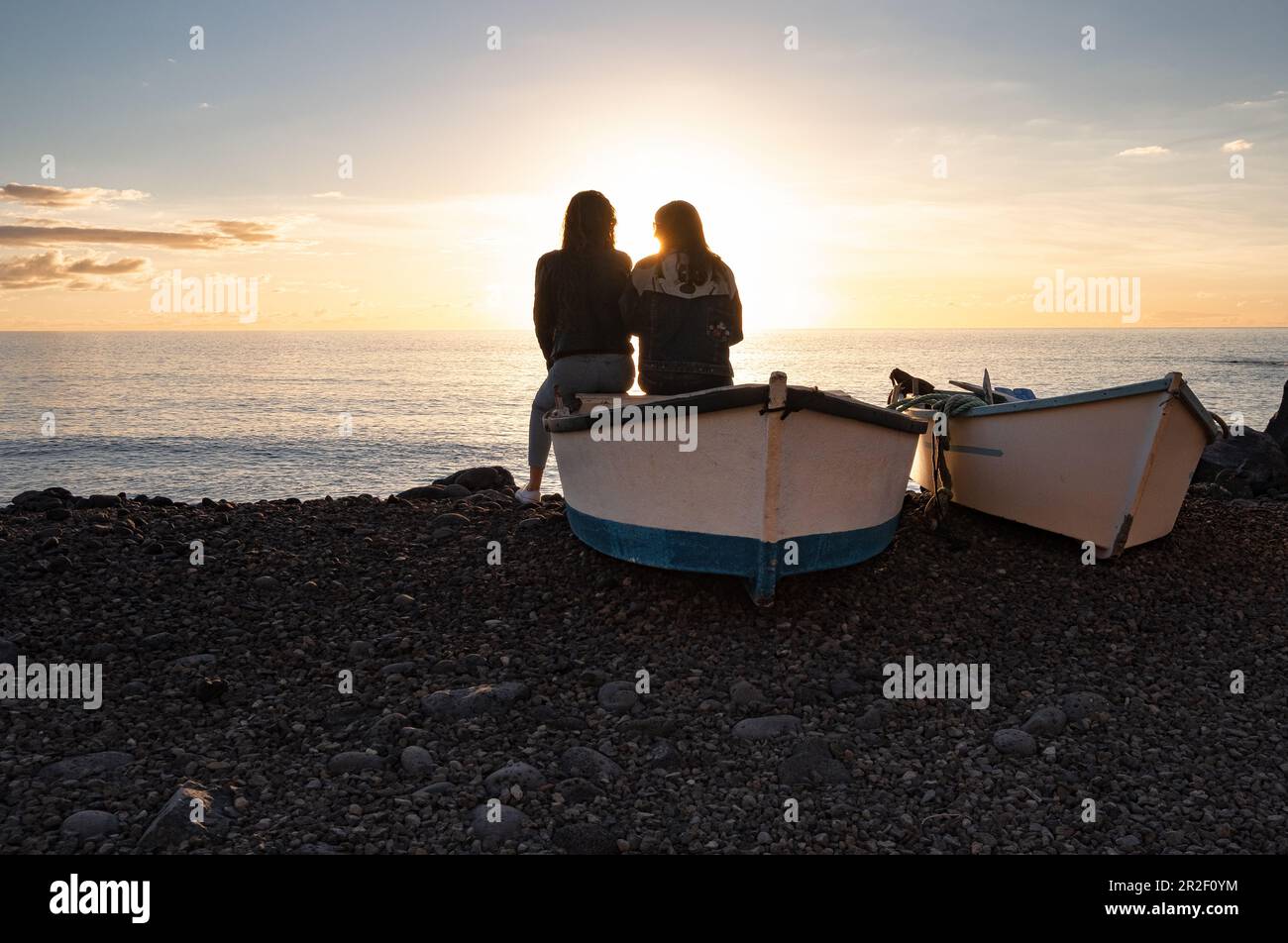 Zwei Frauen sitzen auf einem Boot und blicken auf den Atlantik, El Remo, La Palma, die Kanarischen Inseln, Spanien, Europa Stockfoto