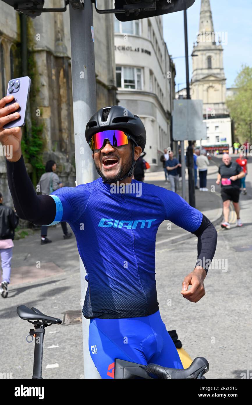 Männlicher Radfahrer mit Sonnenbrille und Helm, der Selfie-Fotos macht, wenn er vom Fahrrad abfährt, Bristol Stockfoto