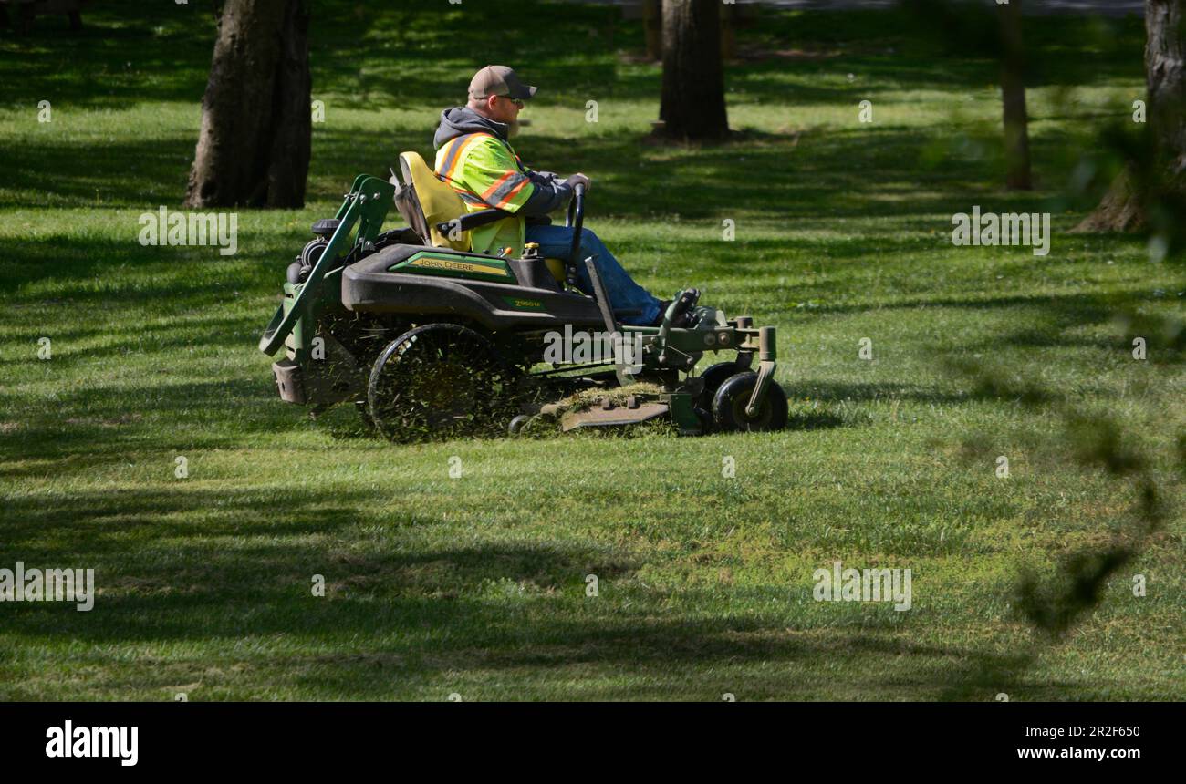 Ein Stadtarbeiter mäht Gras mit einem Aufsitzmäher in einem Stadtpark in Abingdon, Virginia. Stockfoto