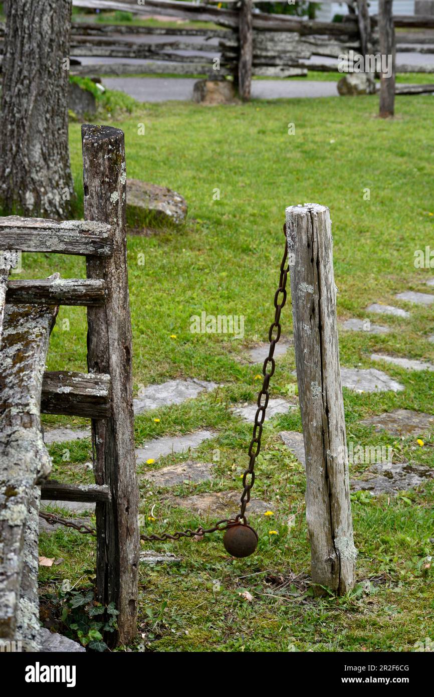 Ein Tor im frühen amerikanischen Stil, das sich aufgrund eines Eisengewichts in einer historischen Blockhütte in Abingdon, Virginia, automatisch schließt. Stockfoto