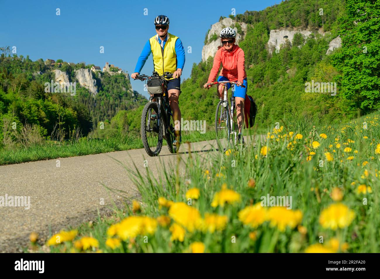 Mann und Frau fahren mit dem Fahrrad durch das obere Donautal, Felsen im Hintergrund, nahe Beuron, Oberes Donautal, Donauradrennbahn, Baden-Württem Stockfoto