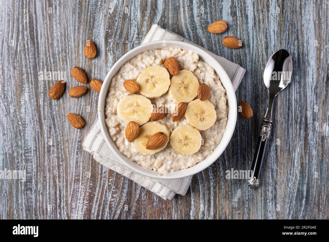 Zubereiteter Haferbrei mit Früchten und Nüssen auf einem Holztisch Stockfoto