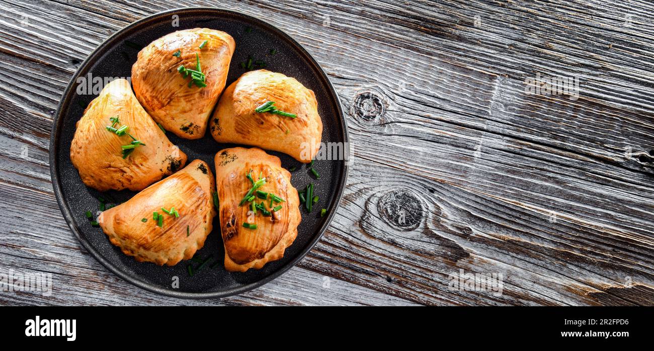 Zusammensetzung mit einem Teller aus im Ofen gebackenen Pierogi Stockfoto