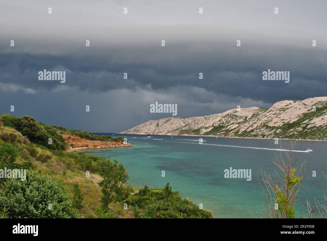 Ein Sturm, der in der Ferne in der Bucht der Insel Rab ankommt. Wind, der zunimmt, und Boote, die mit hoher Geschwindigkeit zum Hafen zurückkehren. Stockfoto