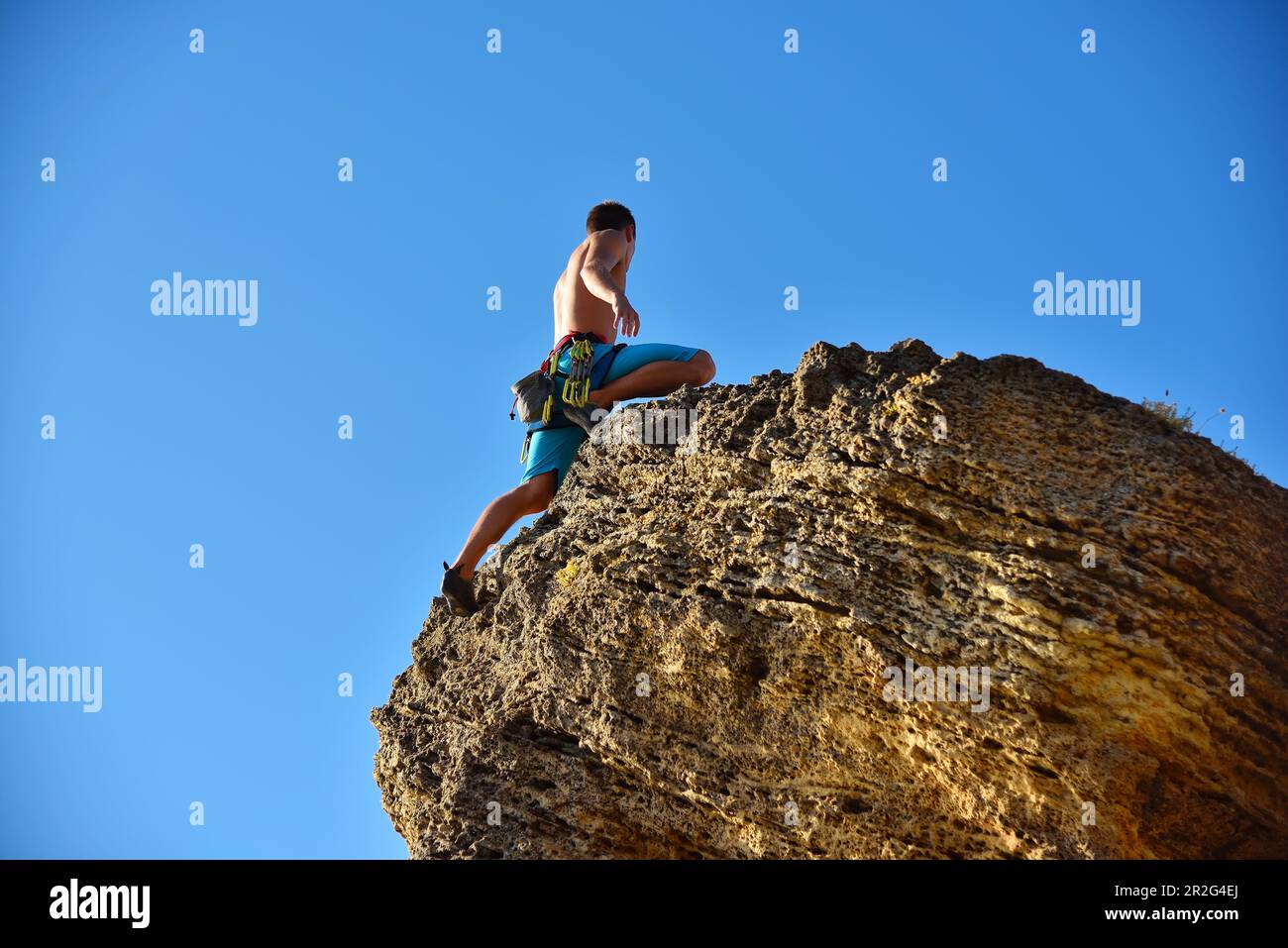Extremkletterer mit Ausrüstung klettert auf einen Felsen Stockfoto