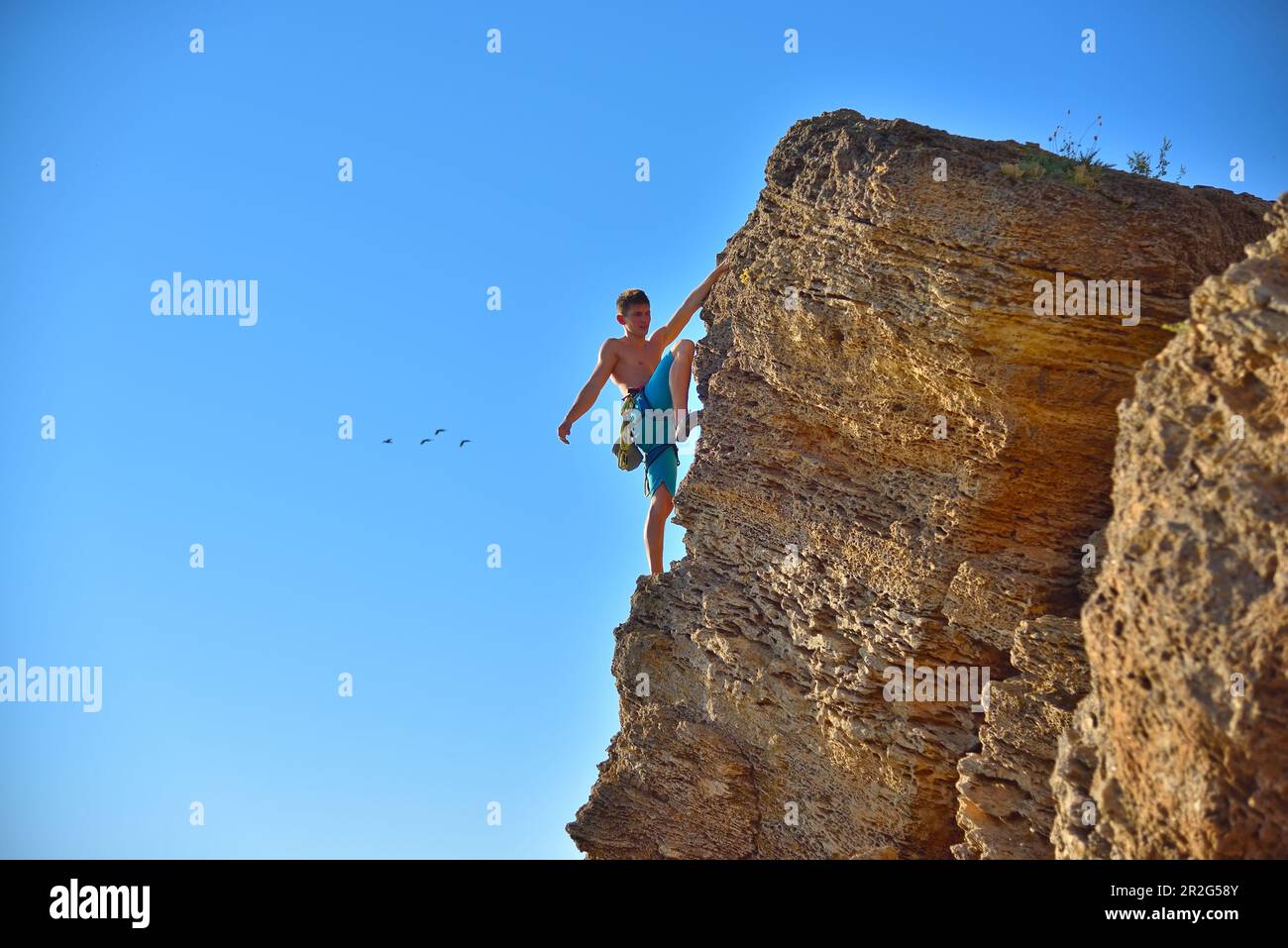 Extremkletterer mit Ausrüstung klettert auf einen Felsen Stockfoto