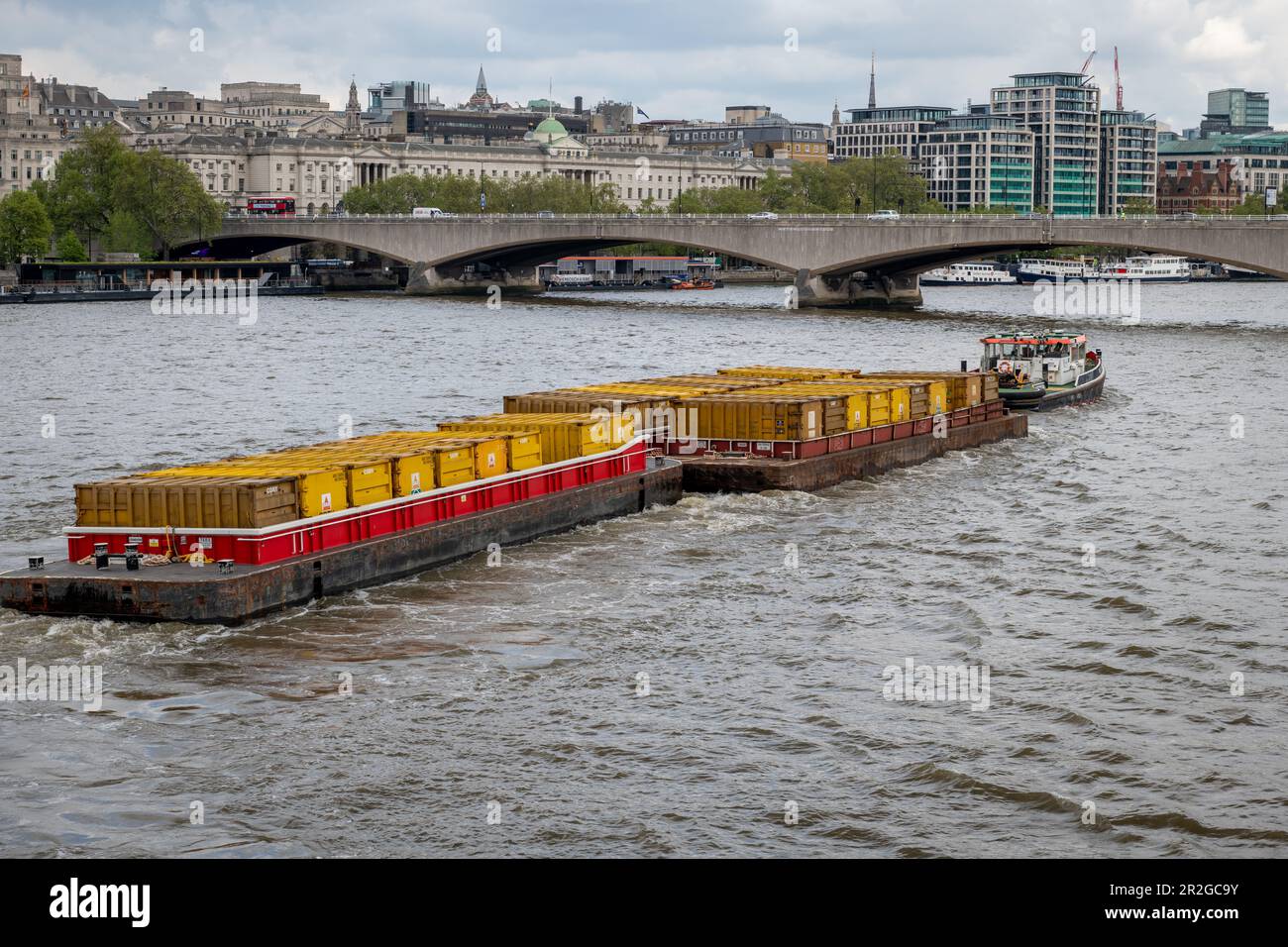 Nach London. GROSSBRITANNIEN - 05.17.2023. Ein Schleppboot, das Frachtkähne voller Container zieht. Transport von Gütern auf dem Wasser auf der Themse. Stockfoto