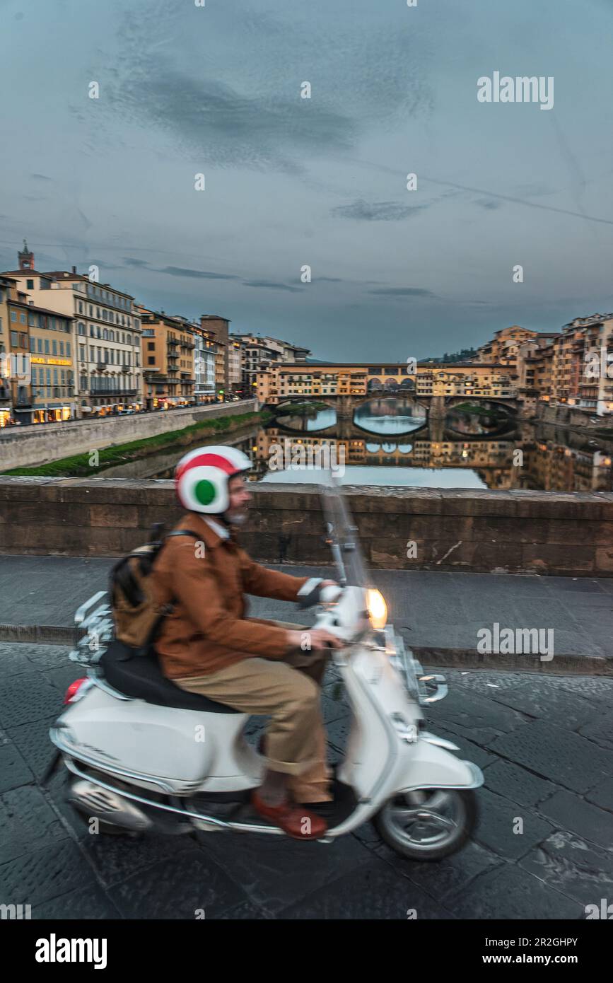 Motorroller fährt über die Santa Trinita Brücke, Abendstimmung über die Ponte Vecchio Brücke, Brücke über den Arno, Florenz, Toskana, Italien, Europa Stockfoto