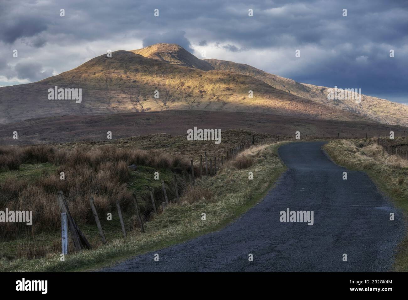 Kleine Straße in den irischen Bergen. wolkiger Himmel. Griggins, Letterbrickaun, County Galway, Irland. Stockfoto