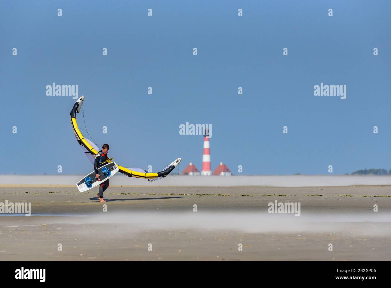 Kitesurfer am weitläufigen Strand im Bezirk Ording, Westerhever Leuchtturm im Hintergrund, St. Peter Ording, Nordfriesland, Nordsee Stockfoto