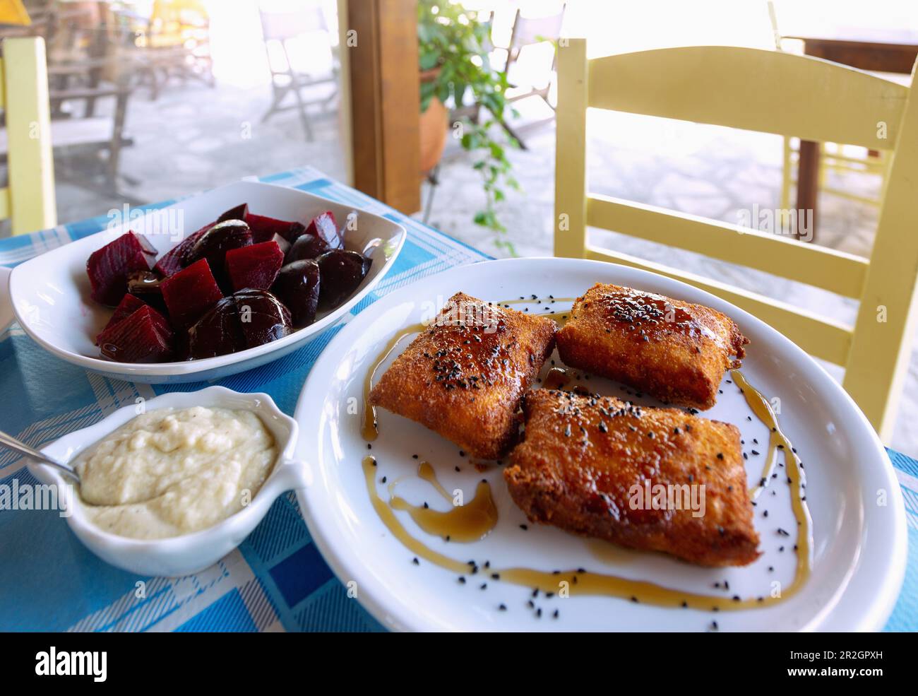 Rote Bete mit Skordalia und Feta in knusprigem Teig mit schwarzem Sesam und Honig, serviert in der Taverne Steki Tou Manoli auf der Platea von Paleokastro on Stockfoto