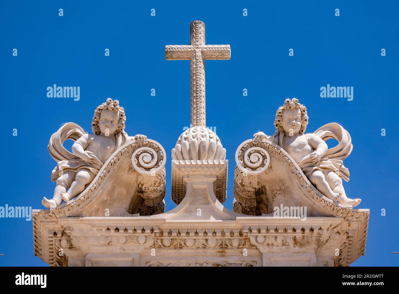 Das Kreuz mit zwei Engeln auf der Spitze der königlichen Abtei von Alcobaca mit blauem Himmel, Portugal Stockfoto