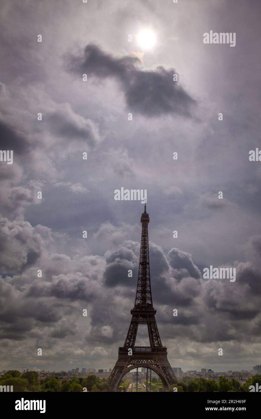 Foto des Eiffelturms in Paris, Frankreich, mit einer Wolke und einer trüben Sonne direkt darüber Stockfoto
