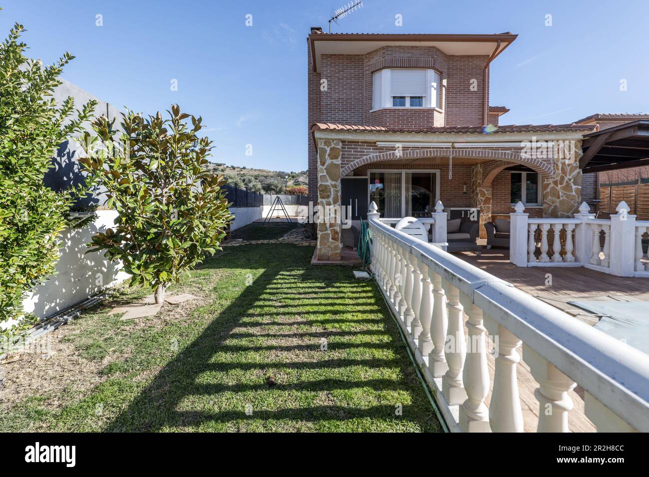 Land mit Gärten und Swimmingpool mit eingebauter Terrasse in einem Einfamilienhaus Stockfoto