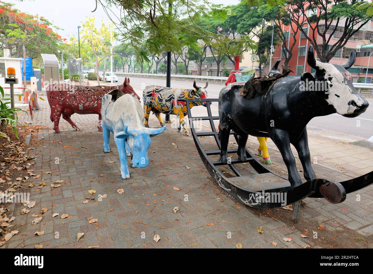 Lebensgroße, farbenfrohe Kuhstatuen für Besucher im Xingfu Park oder Happiness Park in Kaohsiung, Zuoying District, Taiwan; Spielplatzattraktionen Stockfoto