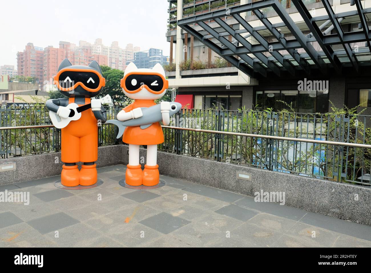 Lebensgroße Katzenstatuen im Xingfu Park oder Happiness Park in Kaohsiung, Zuoying District, Taiwan; niedliche Cartoon-Katzen, die Gitarre und Fisch spielen. Stockfoto