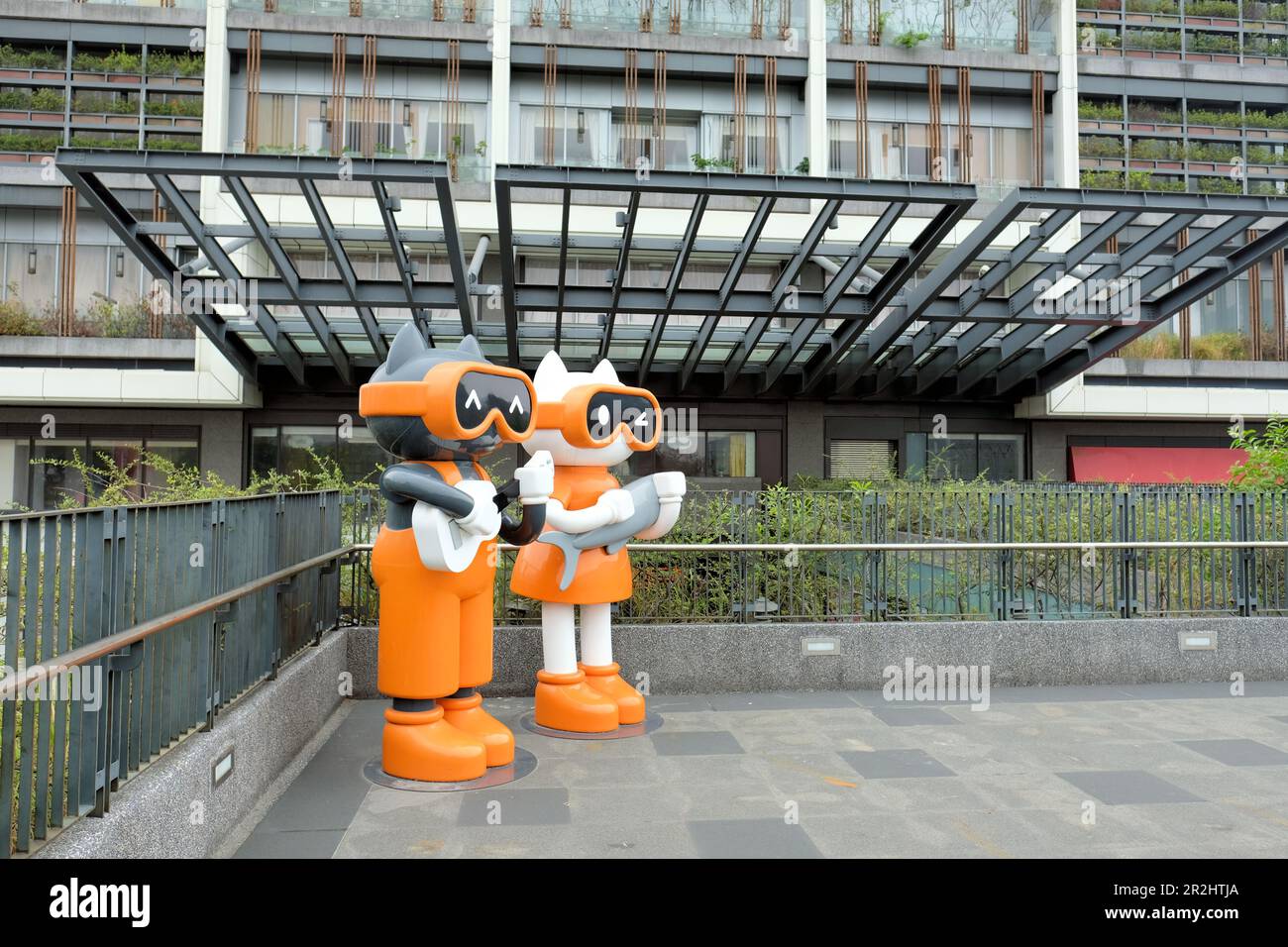 Lebensgroße Katzenstatuen im Xingfu Park oder Happiness Park in Kaohsiung, Zuoying District, Taiwan; niedliche Cartoon-Katzen, die Gitarre und Fisch spielen. Stockfoto