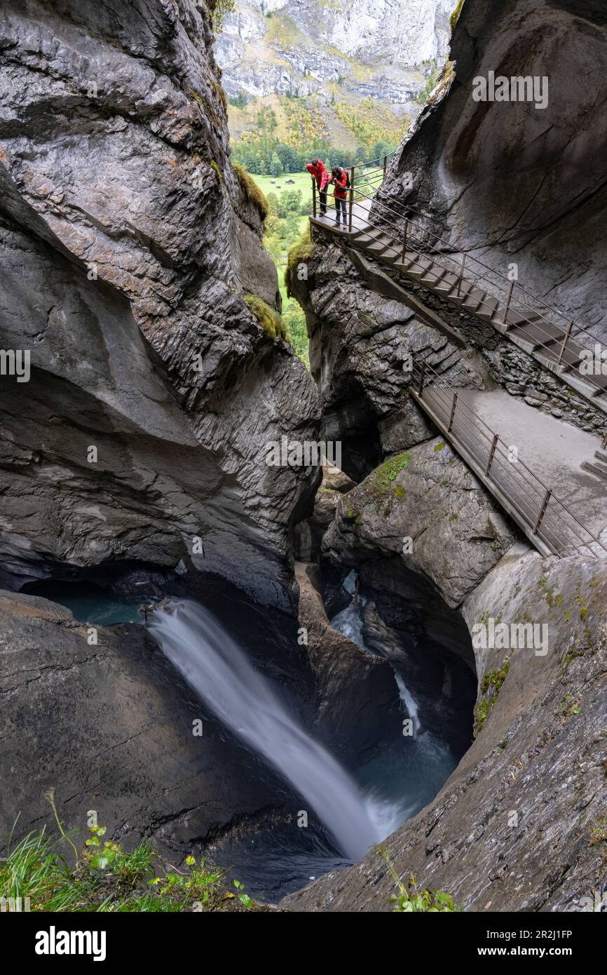 Zwei Wanderer fotografieren die Trummelbachfälle vom Pfad in den majestätischen Felsschluchten, Lauterbrunnen, Kanton Bern, Schweiz, Europa Stockfoto