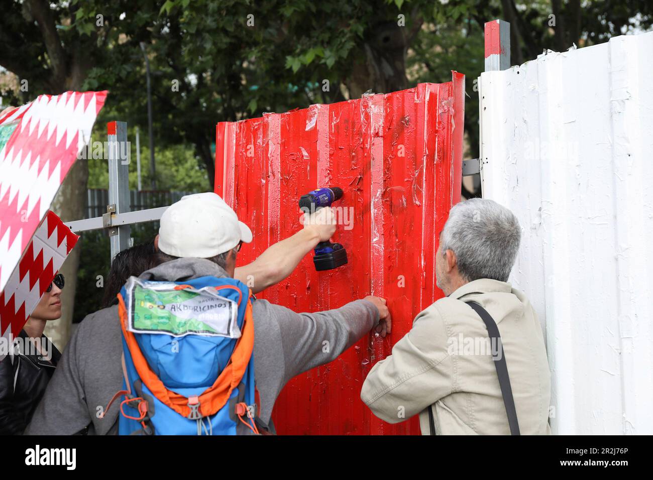 Eine Gruppe von Nachbarn entfernt die Schrauben von den Schließplatten der Nut, bevor sie den Raum betreten, um zu protestieren. Hundert Einwohner des Madrider Bezirks Arganzuela wurden aus dem Madrid Rio Grove vertrieben, wo Arbeiten zur Erweiterung der Linie 11 der Madrid Metro durchgeführt werden. Die Einwohner, die nach der „Nein zum Holzeinschlag“-Plattform gruppiert sind, betraten das Gebiet, um gegen das Gerichtsurteil zu protestieren, das den Antrag von Umweltgruppen abgelehnt hat, die Erweiterungsarbeiten der Linie 11 des Vororts einzustellen. Bei der Durchführung der Arbeiten werden Dutzende von Bäumen und Grünflächen entfernt. Stockfoto