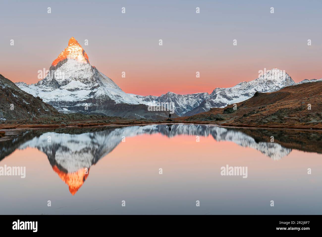 Wanderer bewundern das Matterhorn, das sich bei Sonnenaufgang im Riffelsee spiegelt, Gornergrat, Zermatt, Kanton Wallis, Schweiz, Europa Stockfoto