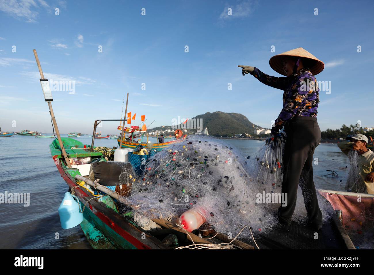 Frau mit dem traditionellen vietnamesischen konischen Hut, die Fischernetze repariert, Hang Dua Bay, Vung Tau, Vietnam, Indochina, Südostasien, Asien Stockfoto