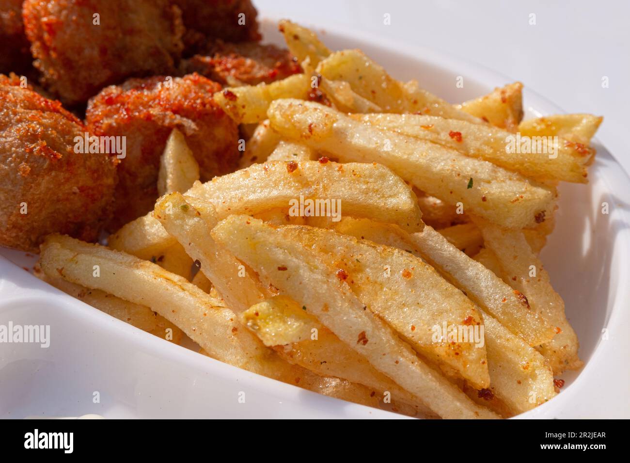 Pommes Frites auf einem weißen Teller auf weißem Hintergrund Stockfoto