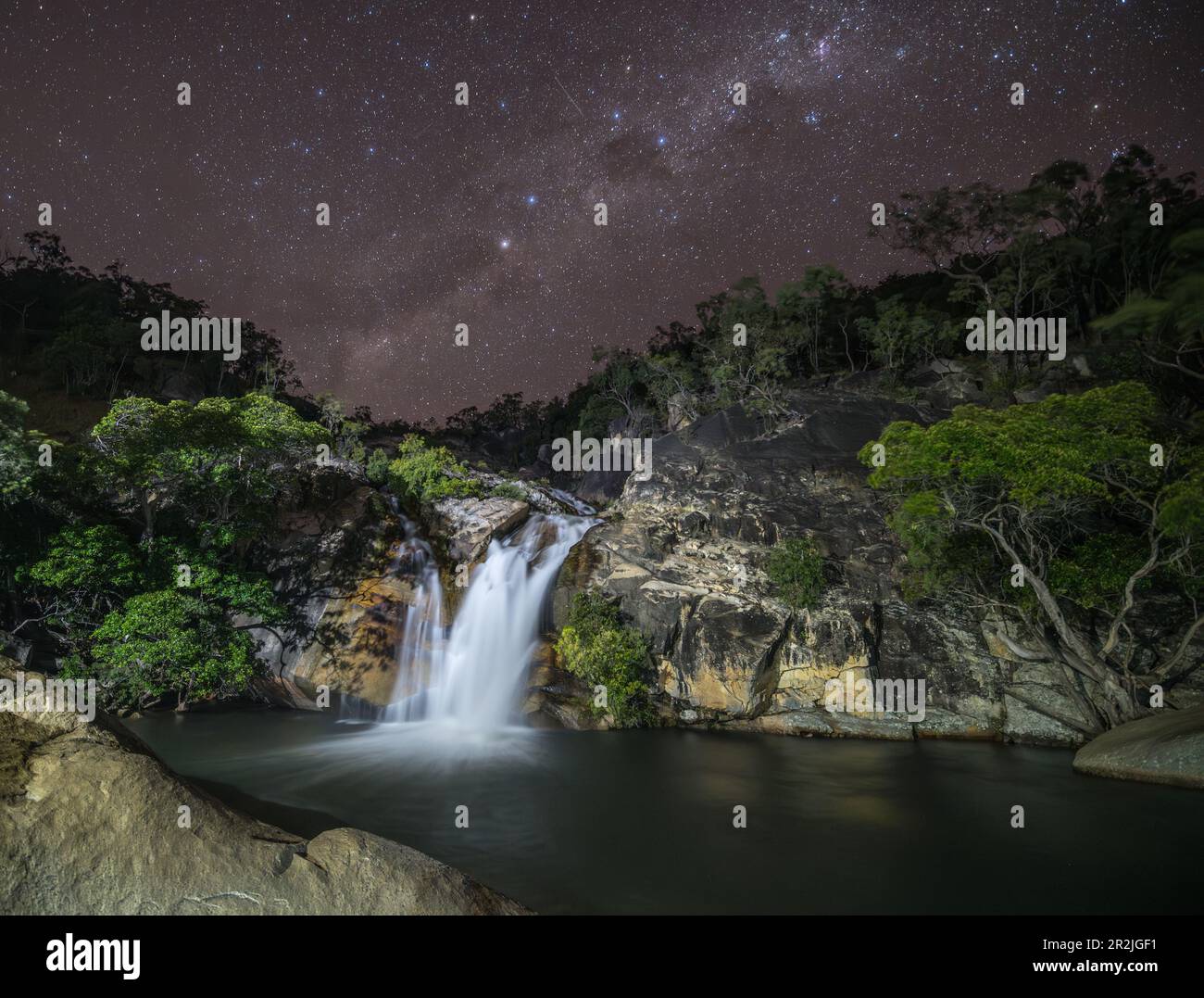 Ein atemberaubendes Nachtbild der Emerald Creek Falls, durchquert von der Milchstraße in einer klaren Nacht in Mareeba, Queensland, Australien. Stockfoto