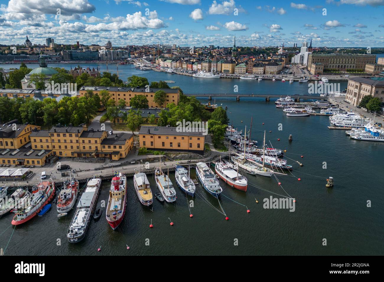 Luftaufnahme der Boote entlang der Insel Skeppsholmen mit der Stadt dahinter, Stockholm, Stockholm, Schweden, Europa Stockfoto