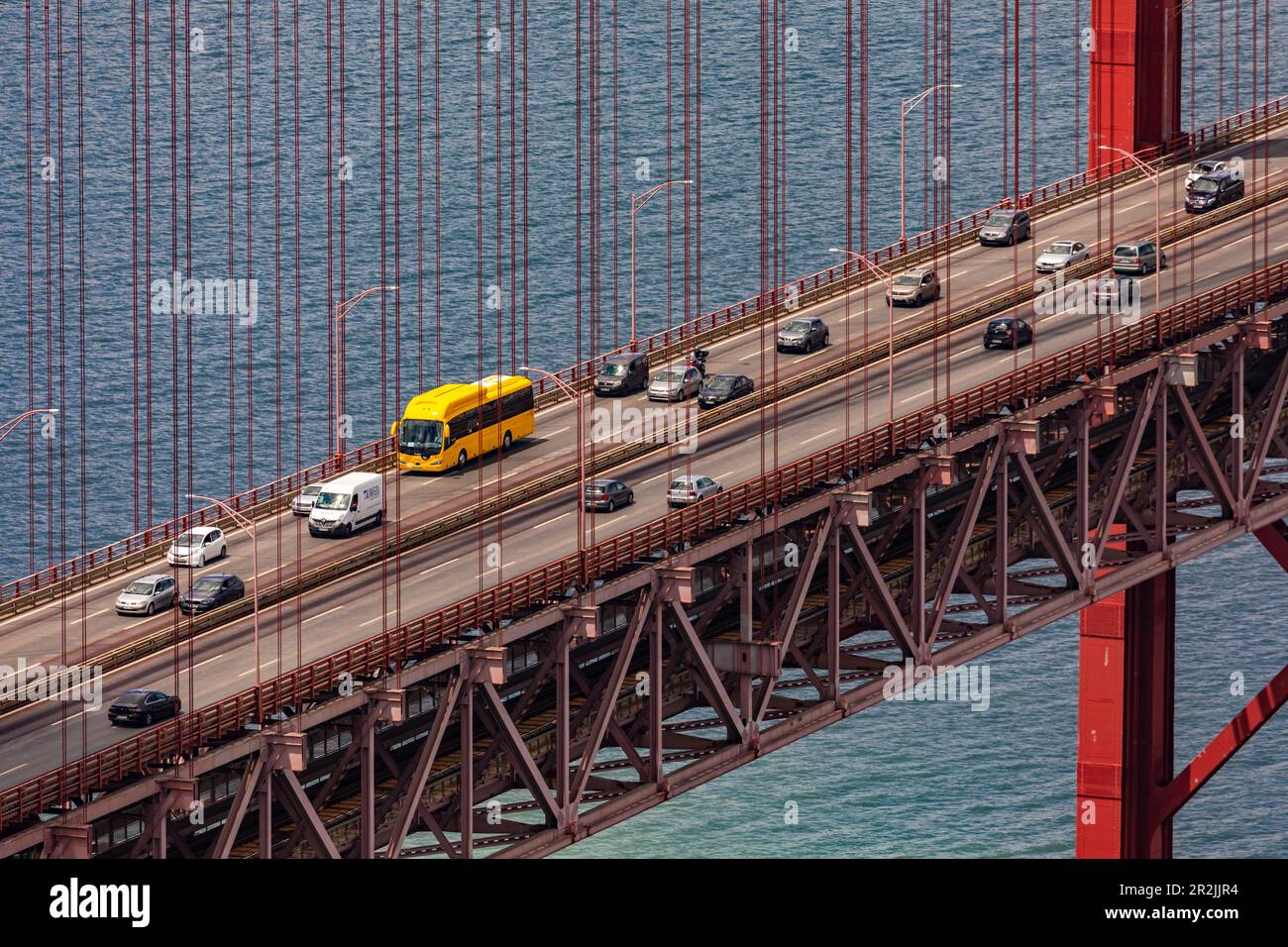 Detail der Brücke über den Fluss Tejo vom 25. April mit Autos und einem gelben Bus unter den Brücken, Lissabon, Portugal Stockfoto