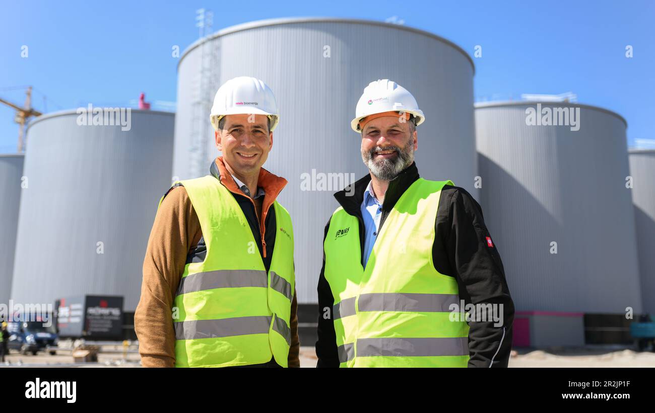 Friesoythe, Deutschland. 08. Mai 2023. Simon Detscher (l), Geschäftsführer der revis Bioenergy GmbH, und Jan-Hendrik Friedrichs, Betriebsleiter der nordfuel-GmbH, stehen vor den Tanks einer im Bau befindlichen riesigen Biogasanlage. Eine der größten Biogasanlagen in Europa wird derzeit auf einer Fläche von mehr als 13 Hektar in einem Industriegebiet in der Nähe der Kleinstadt Friesoythe bei Cloppenburg gebaut. (An dpa „Biomethan-Anlage im XXL-Format liefert Brennstoff aus Gülle und Gülle“) Kredit: Mohssen Assanimoghaddam/dpa/Alamy Live News Stockfoto